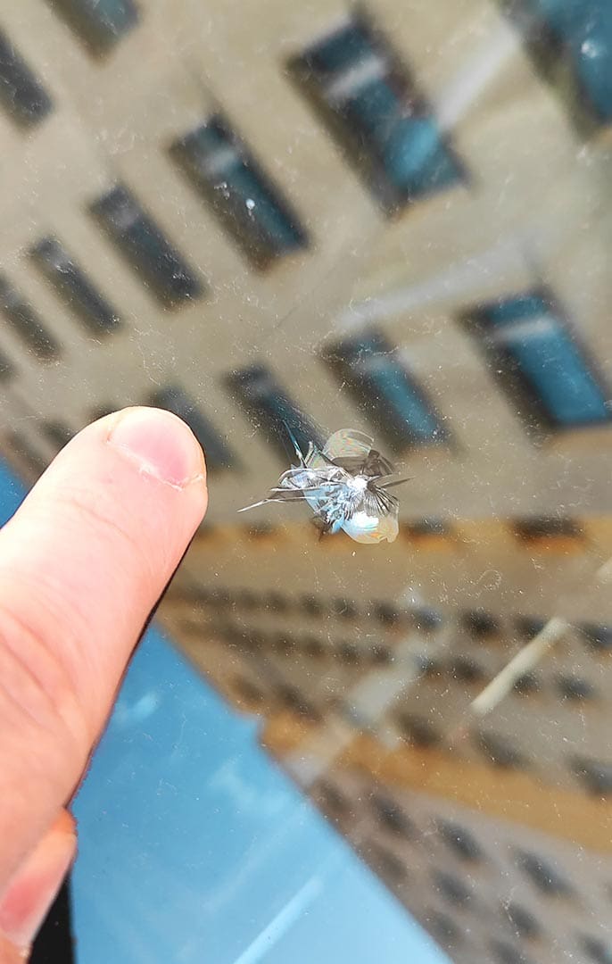 Chipping on the windshield of the car.